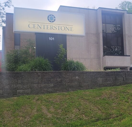 Centerstone sign above the entrance of a brick and stone building marked 101.