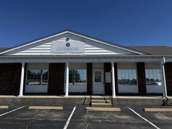 Front exterior of a brick-and-white-sided Centerstone building with a parking lot and Centerstone sign above the entrance.