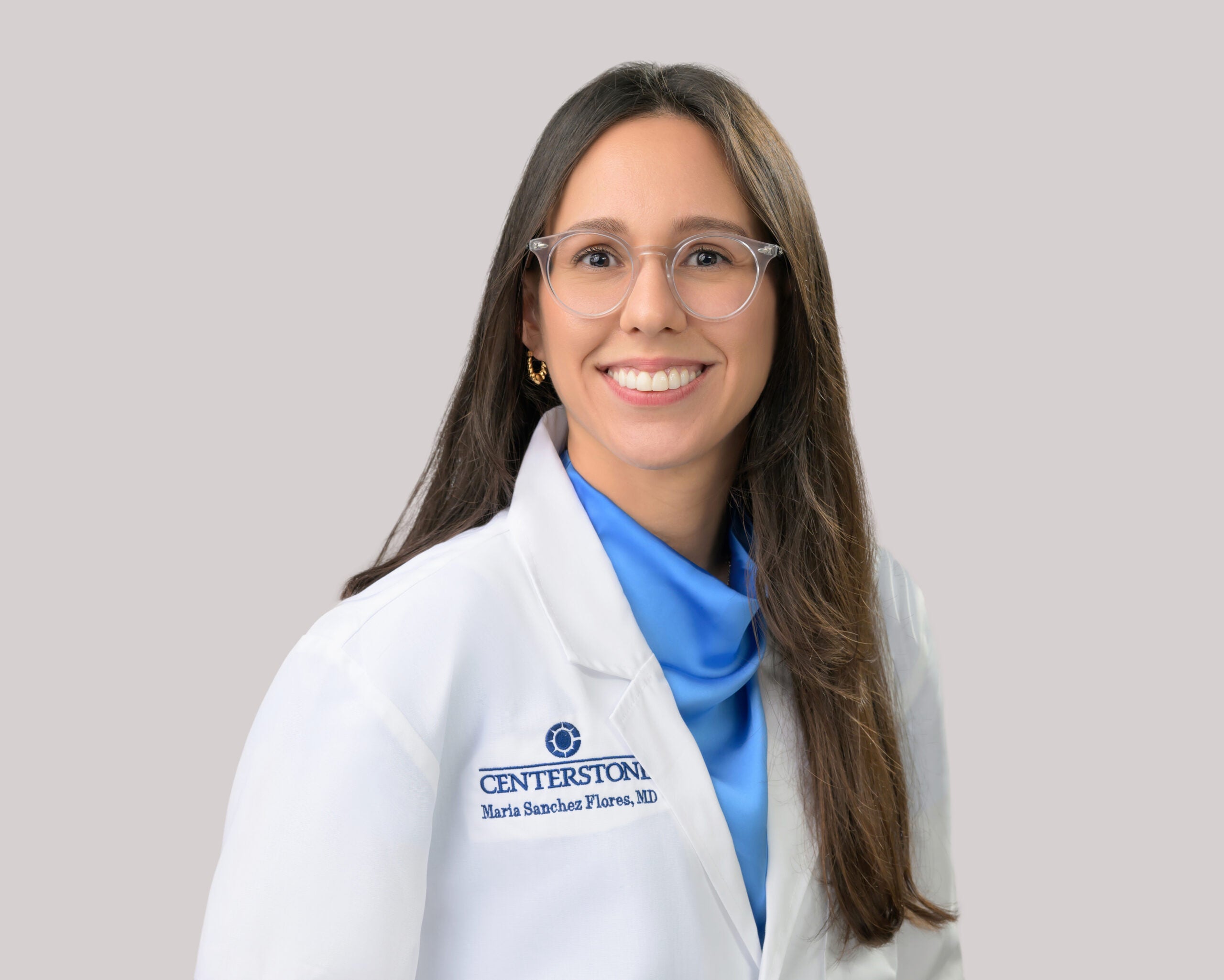 Portrait of Maria Sanchez Flores, M.D. in a white lab coat