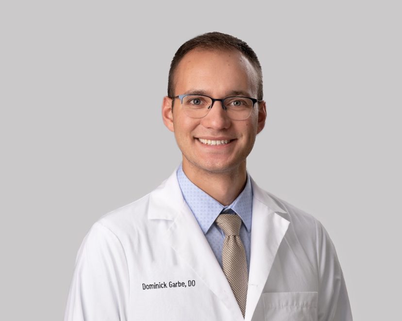 Portrait of Dominick Garbe, D.O. in a white lab coat