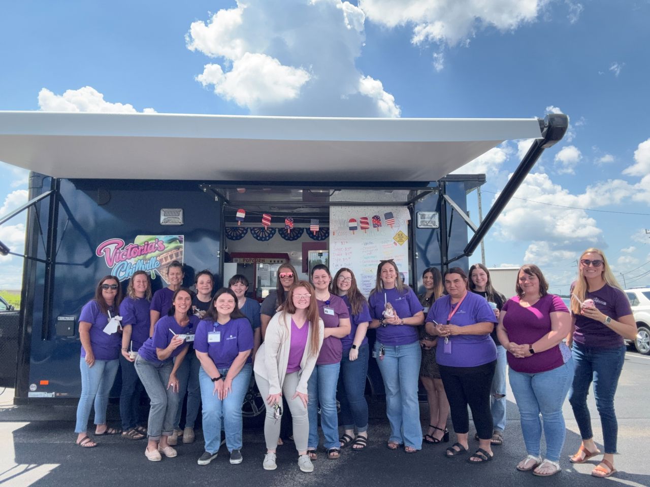 Seymour Team IceCream Centerstone staff gathered in front of a food truck enjoying ice cream on a sunny day.